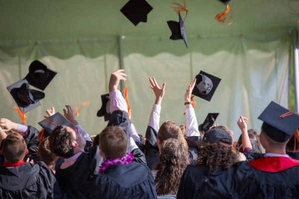 Graduates celebrating by tossing caps into the air, symbolizing success and achievement supported by the innovative strategies of the best digital marketing company in Kerala.