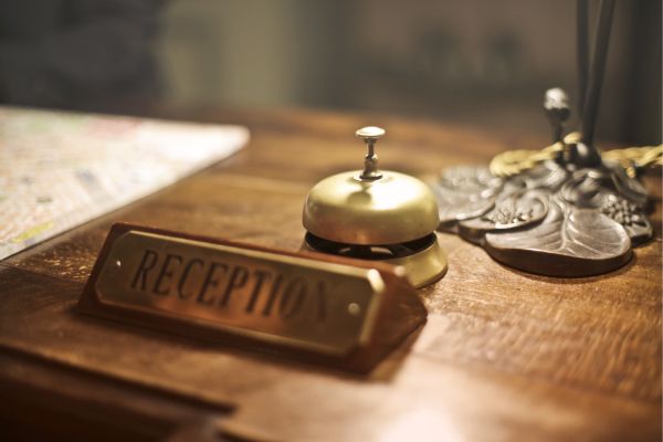A hotel reception desk with a golden service bell and a reception sign, symbolizing premium hospitality supported by Digital Marketing Services in India.