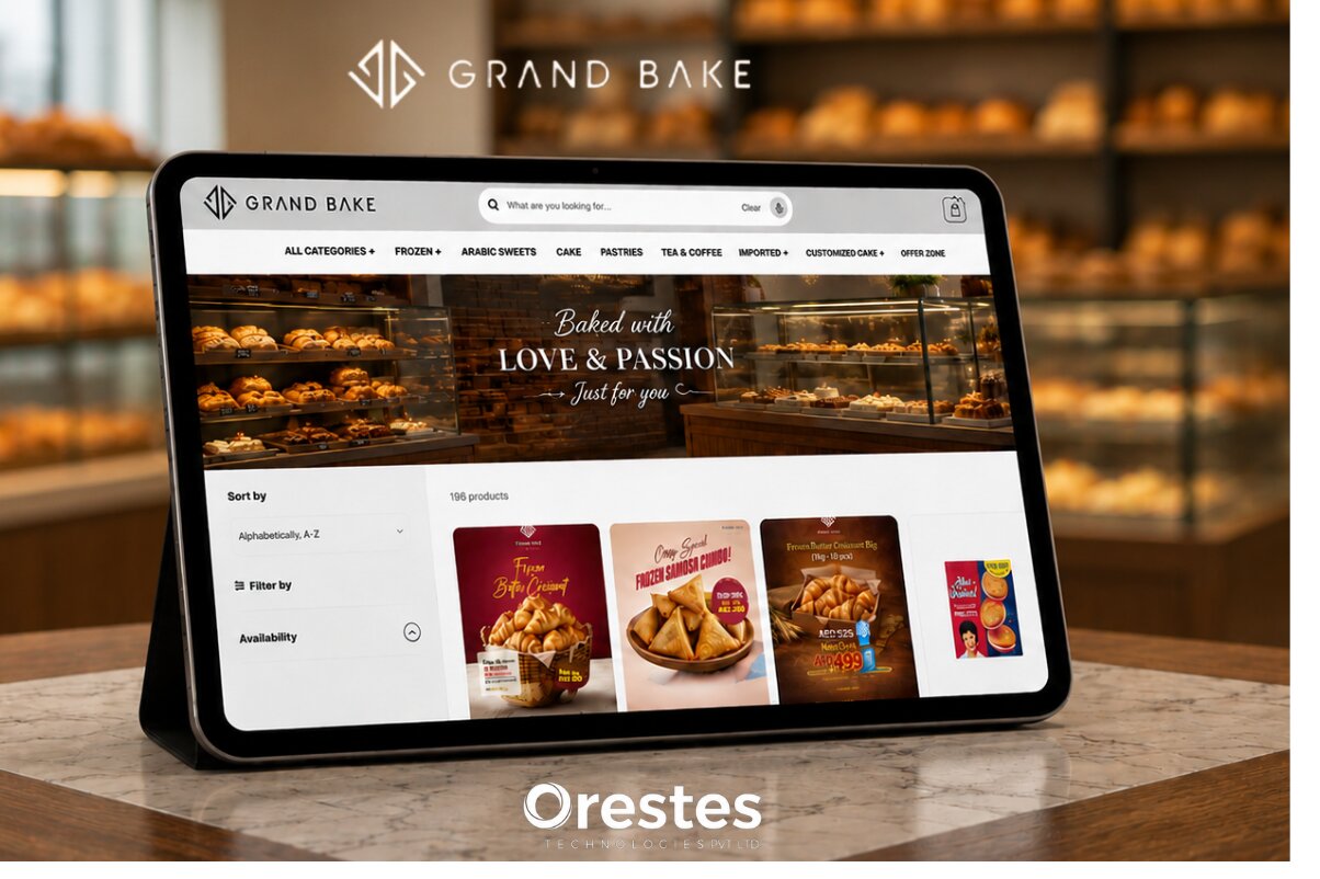 Grand Bake e-commerce website interface displayed on a tablet mockup over a marble counter, featuring a blurred bakery display background and an Orestes Technologies logo is visible at the bottom.