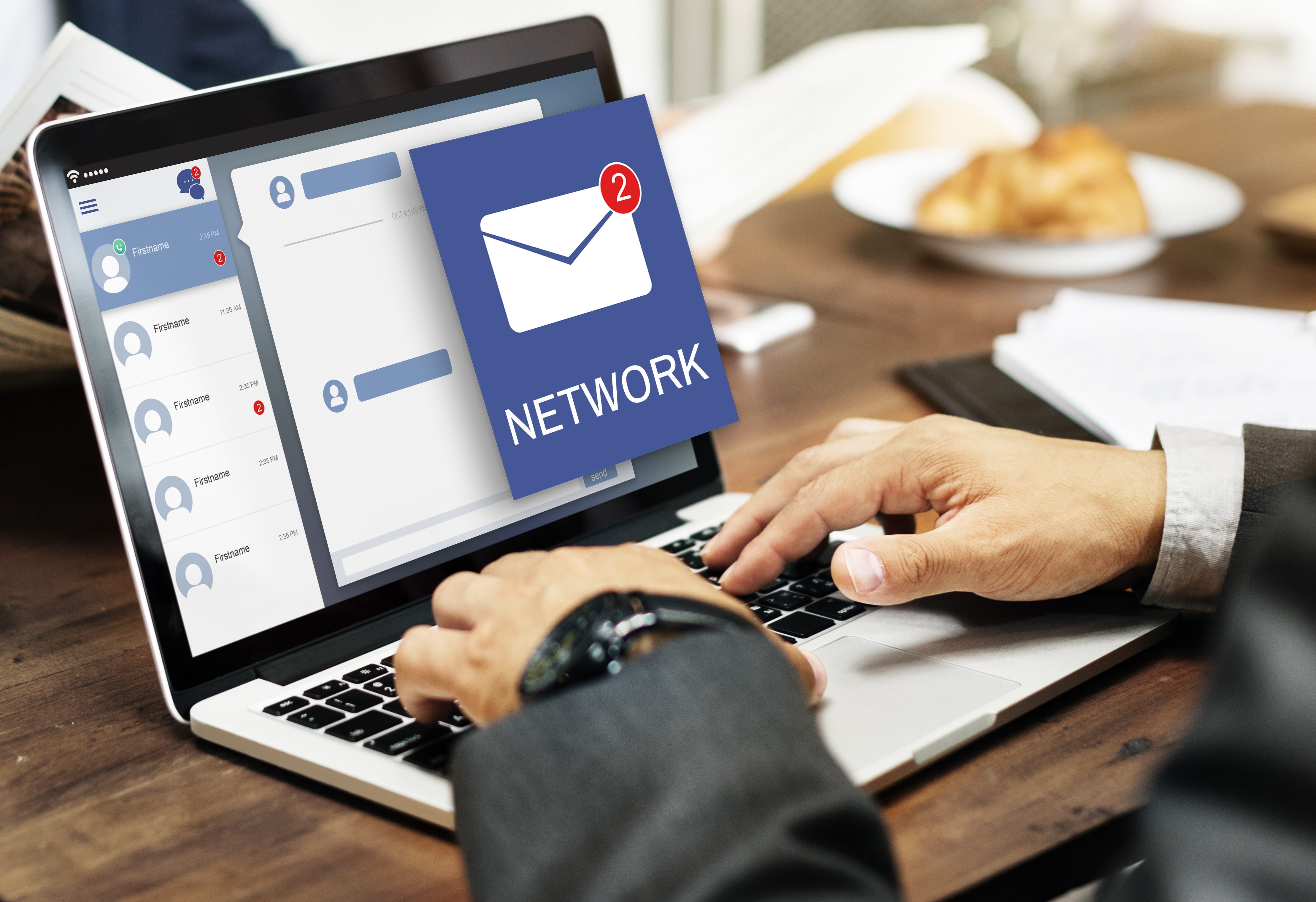 A professional typing on a laptop displaying an email and chat interface with a network notification icon, representing digital communication at an SEO agency in Kochi.